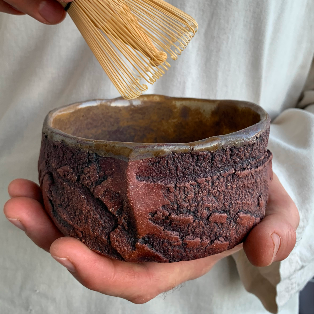 Handmade ceramic bowl in hands, thick-walled stoneware kurinuki bowl