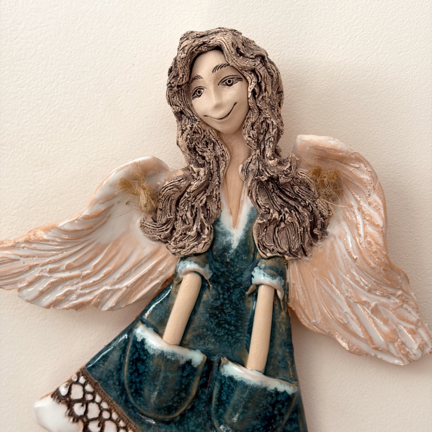 Decorative angel figurine with teal dress and soft expression