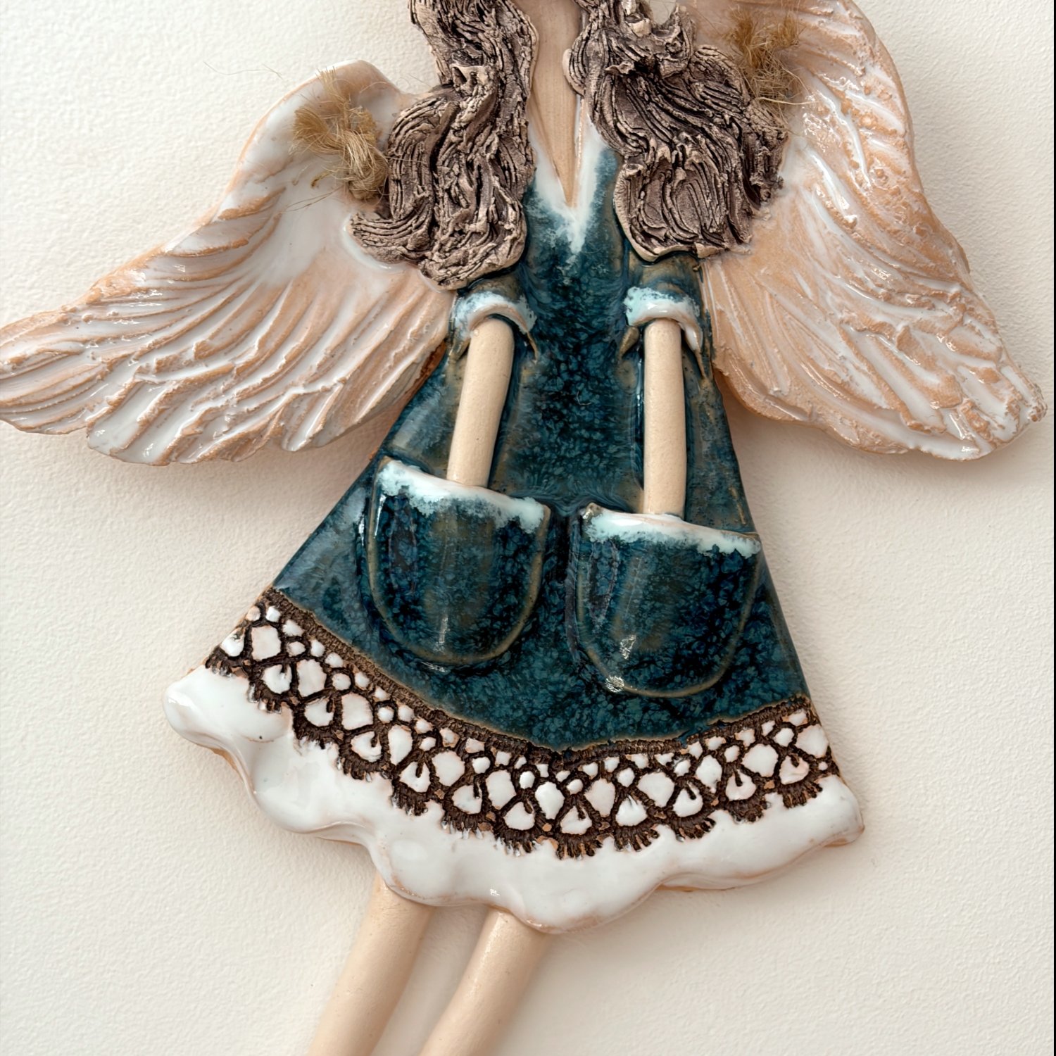 Ceramic angel artwork showing detailed wing and dress texture