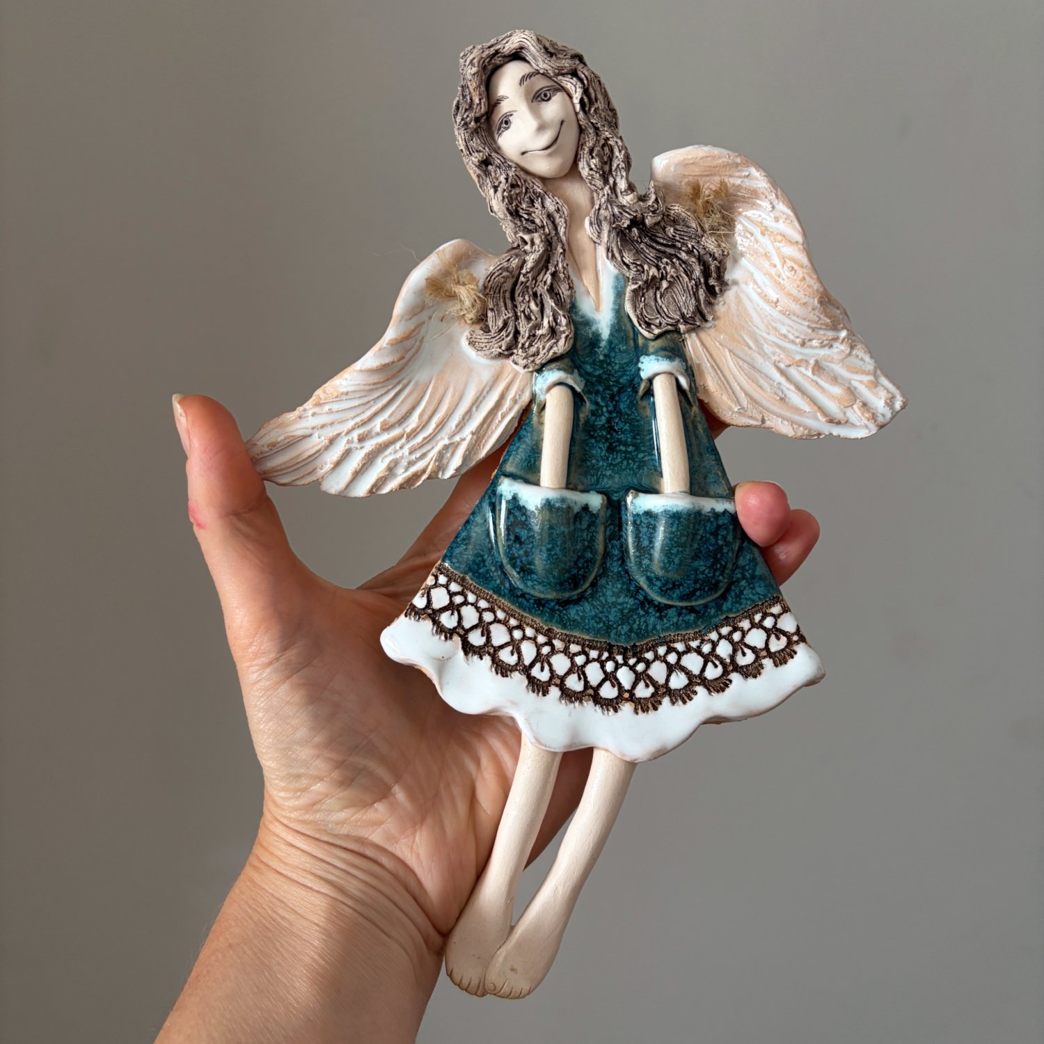 Handcrafted angel figurine with turquoise clothing and detailed wings
