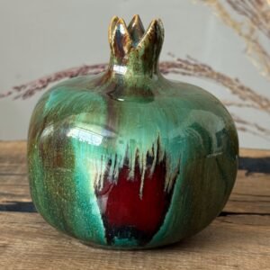 Handmade ceramic pomegranate with organic green glaze and contrasting color patches