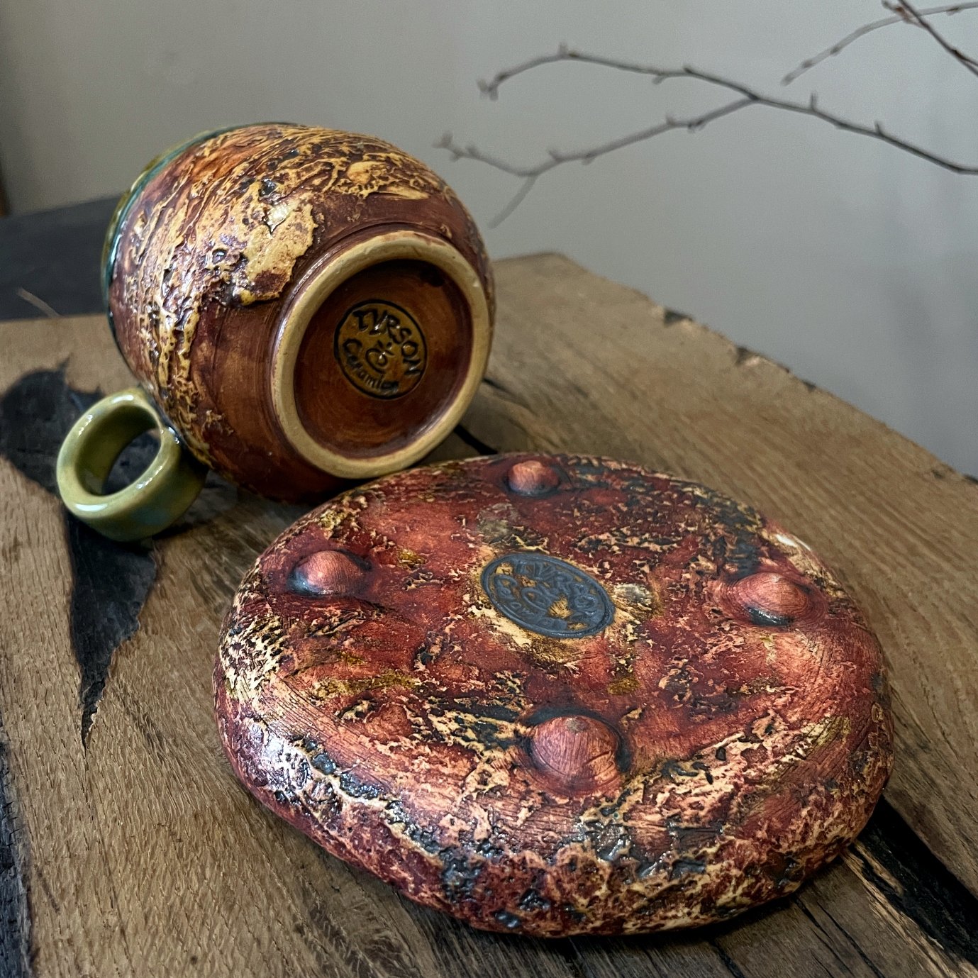 Ceramic tea cup with matching saucer on small ceramic feet