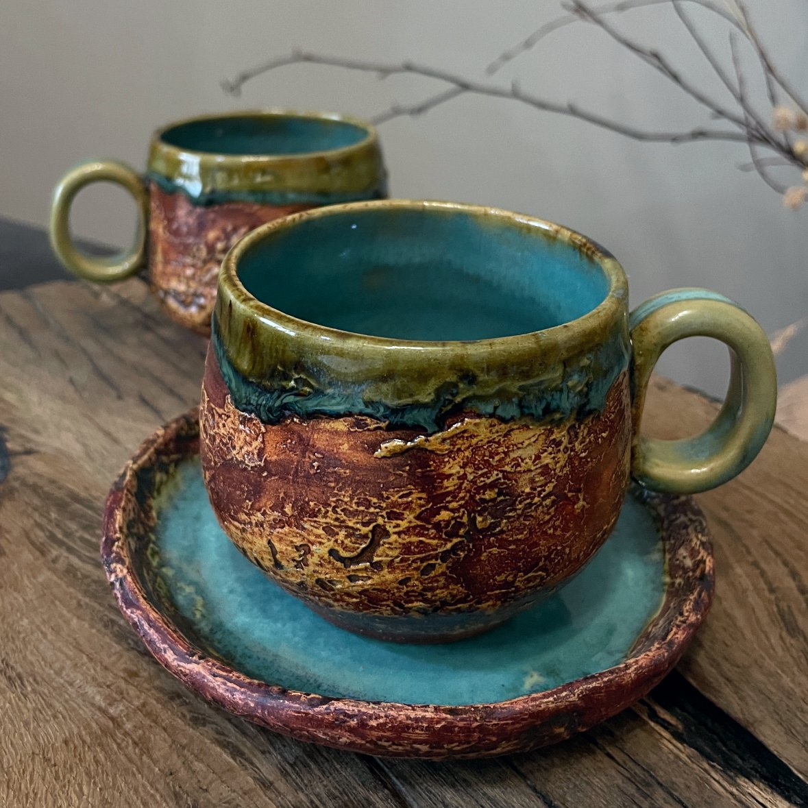 Textured handmade ceramic cup and saucer on wooden table