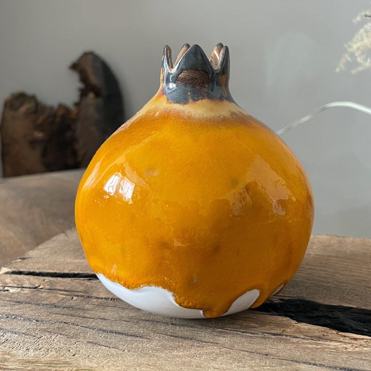 Unique pottery pomegranate figurine with glossy yellow finish and sculpted crown detail