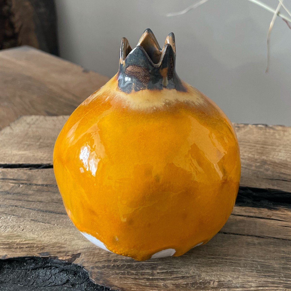 Small ceramic pomegranate vase with dried stems, warm yellow glaze and minimal form