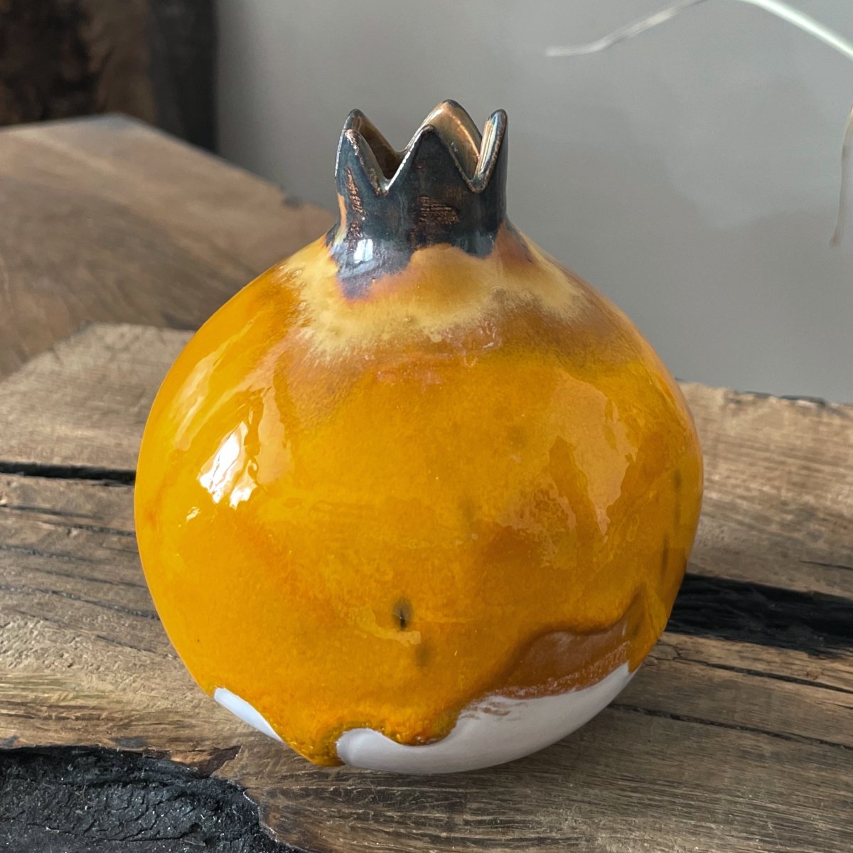 Handcrafted ceramic pomegranate with rich yellow glaze and natural clay base, home decor accent