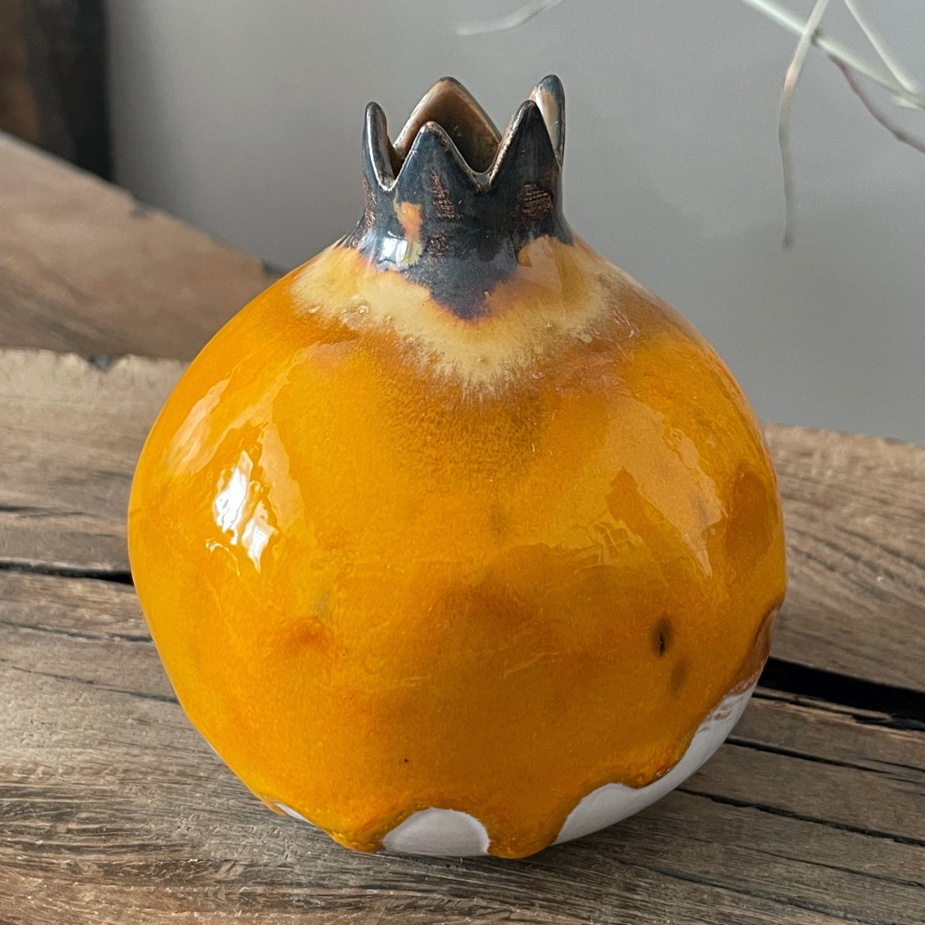 Artistic pottery pomegranate with smooth yellow surface and white contrast, unique ceramic object