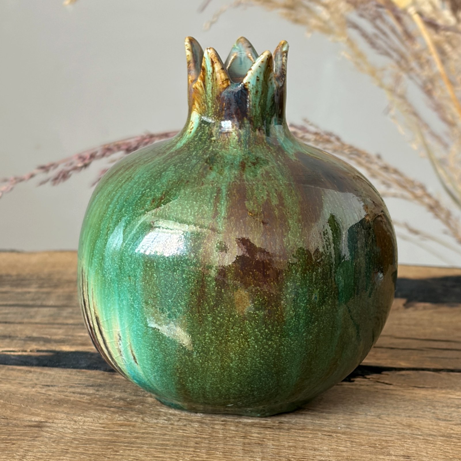 Decorative ceramic pomegranate with rich forest green glazed surface