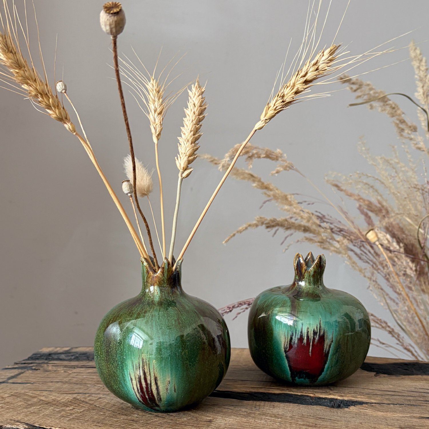 Green handmade pomegranate vase styled with dried botanical stems
