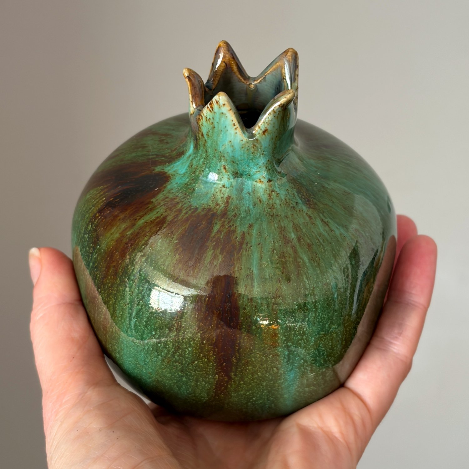 Glazed pottery pomegranate with deep green and earthy tones