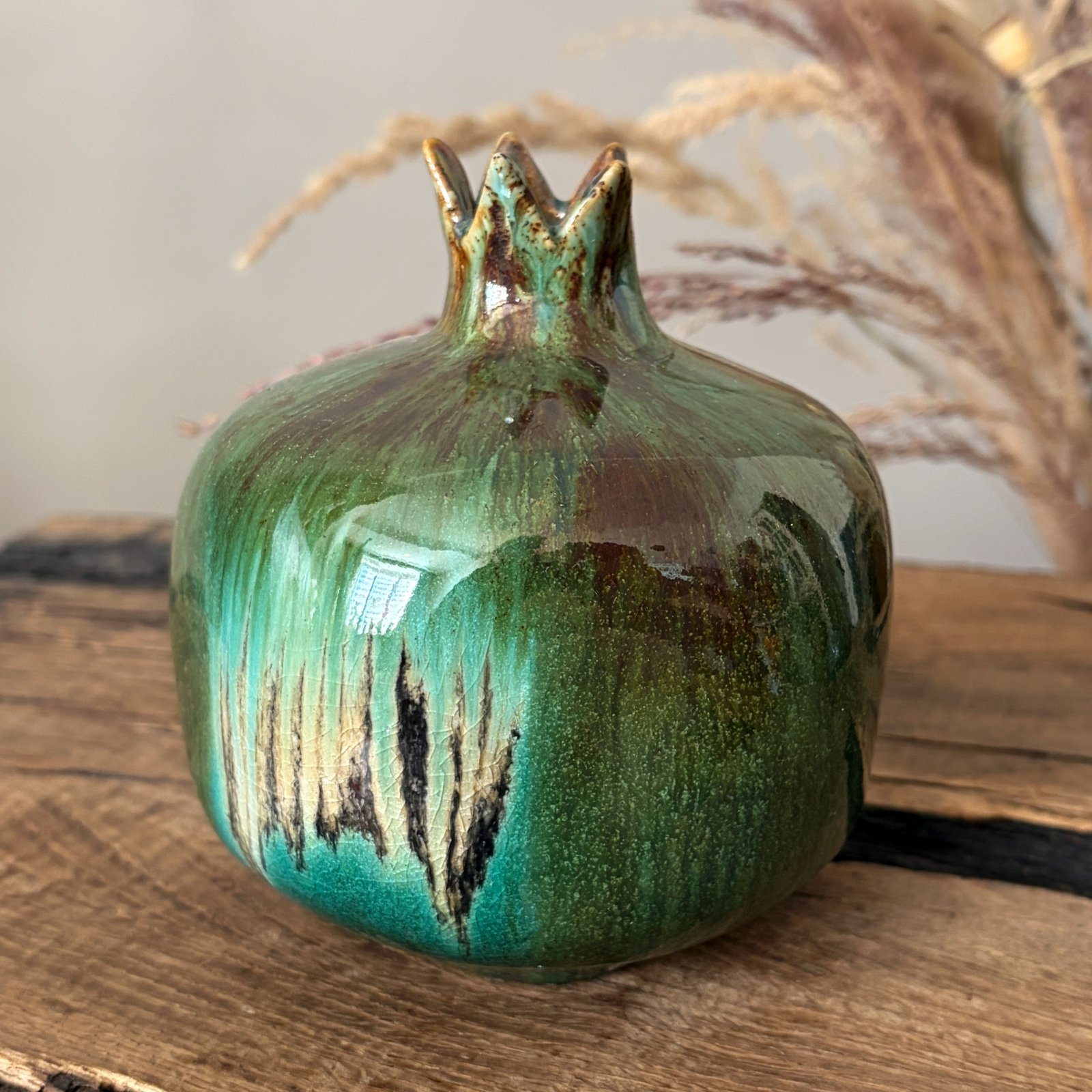 Handmade green ceramic pomegranate with organic glazed texture