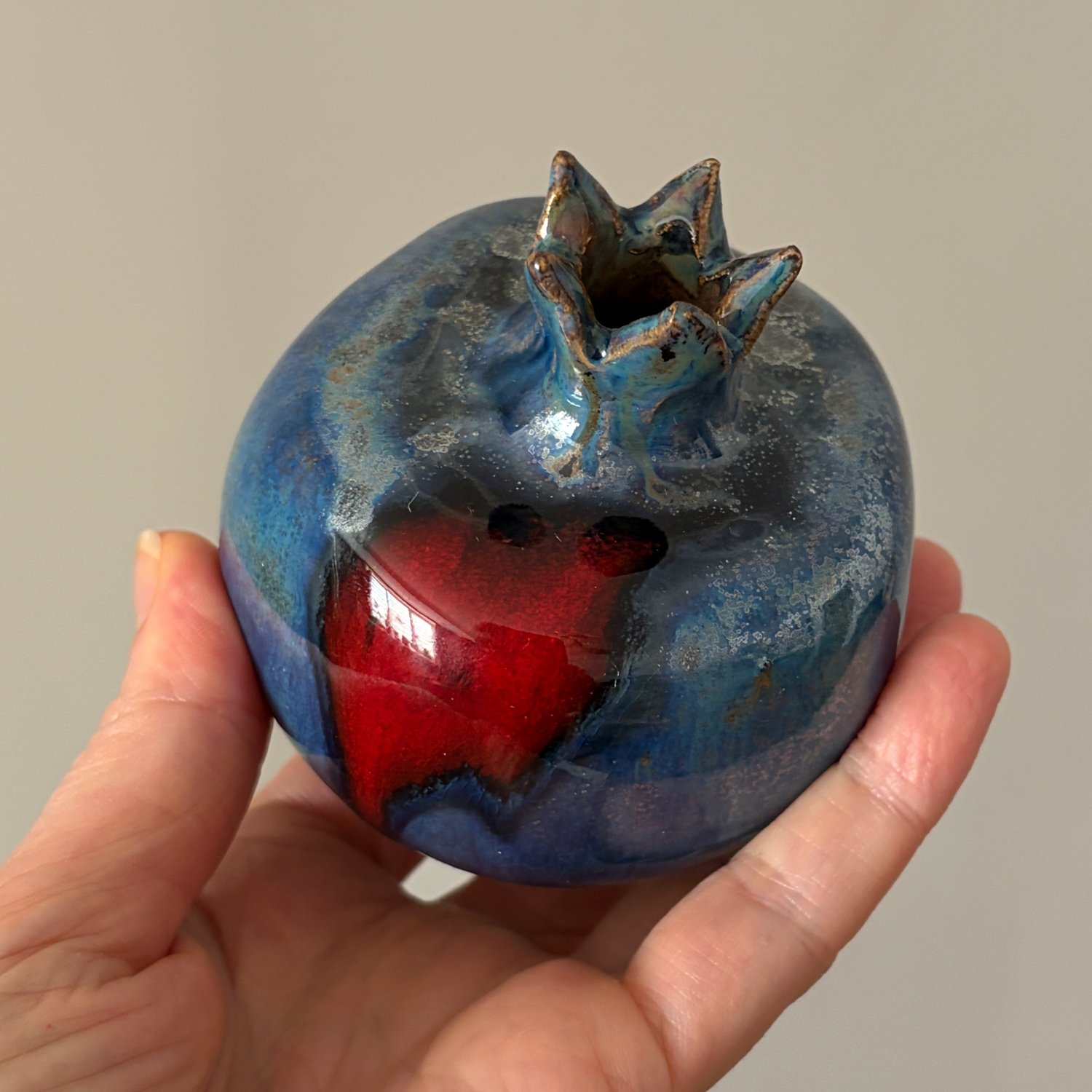 Decorative handmade pomegranate with rich cobalt blue and red glaze