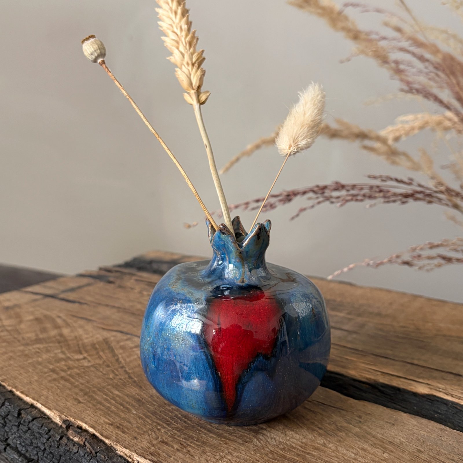 Handmade blue ceramic pomegranate vase with dried flowers