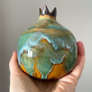 Artistic ceramic pomegranate with glossy green-blue glaze, handmade pottery decor object