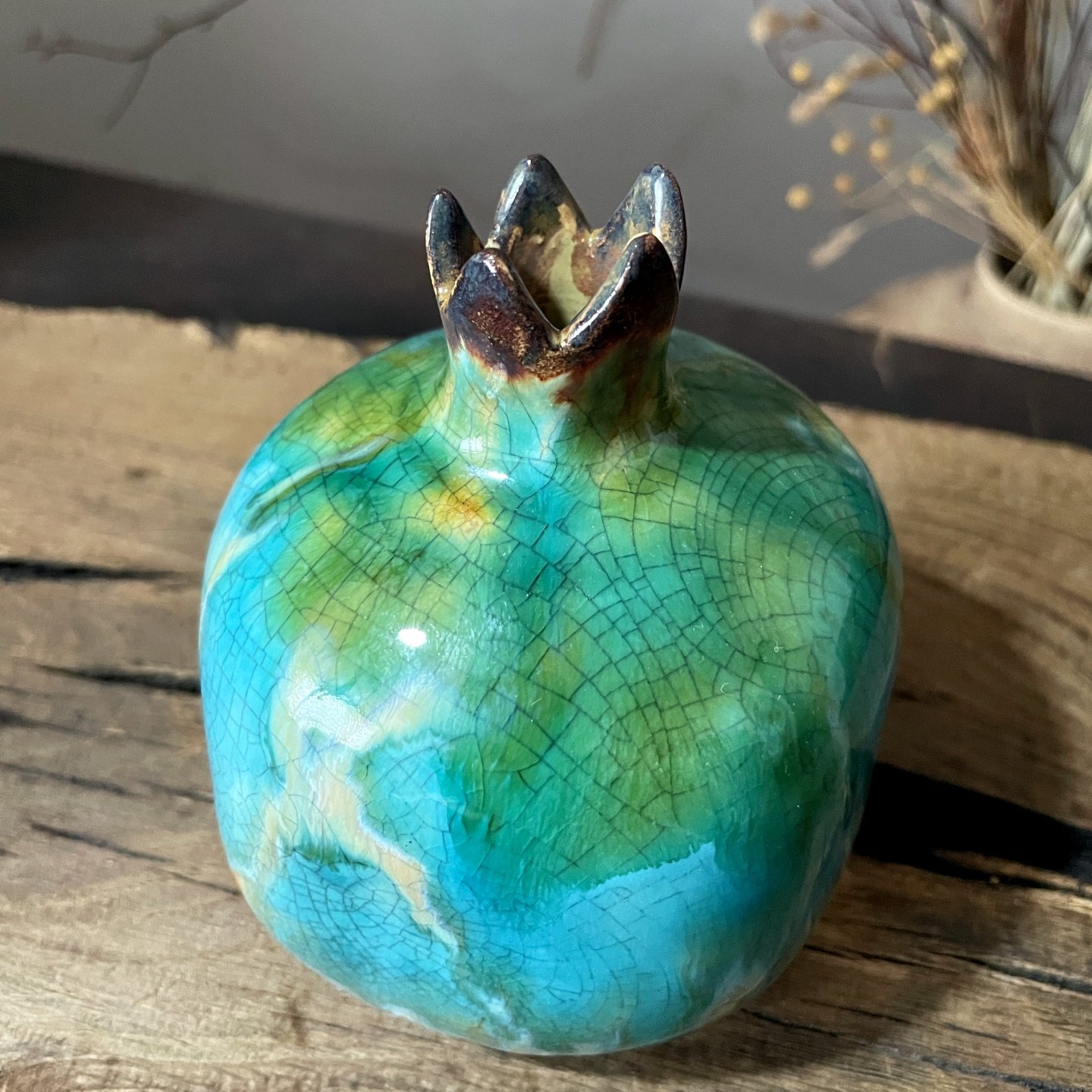 Ceramic pomegranate vase featuring decorative crown opening