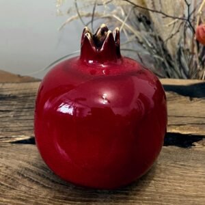 handmade ceramic pomegranate sculpture, red pottery fruit decor on wooden table
