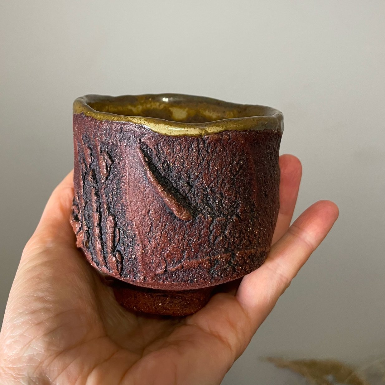 Textured ceramic yunomi cup on neutral background