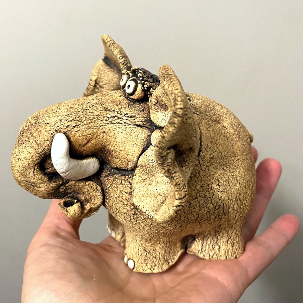 Size reference of handmade ceramic elephant sculpture in hand