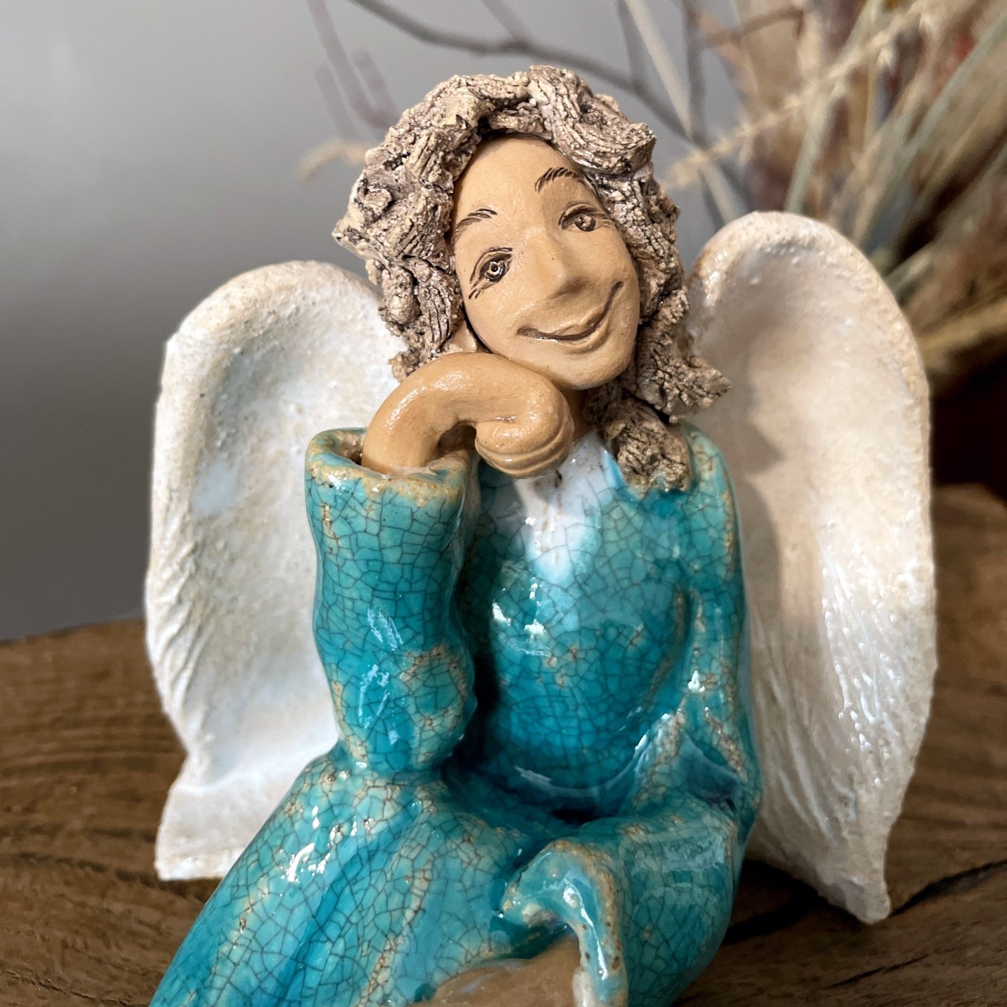 Side view of handmade ceramic angel with textured wings
