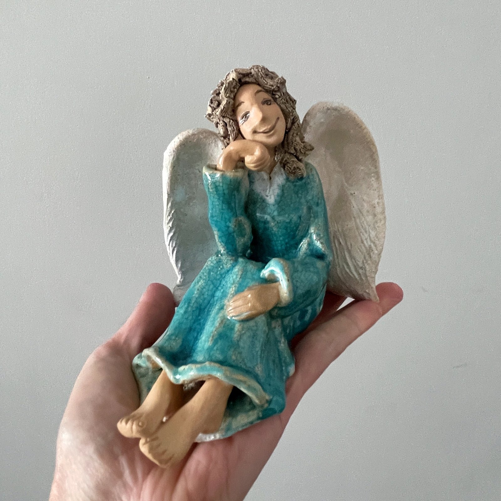 Handmade ceramic angel held in hand for size reference