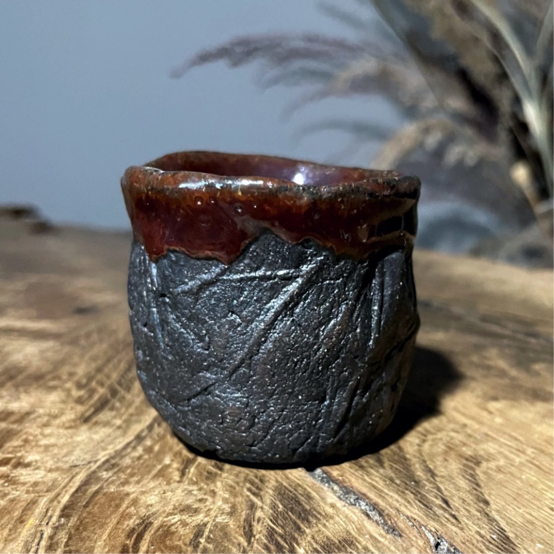 Textured black ceramic cup side view