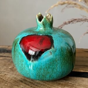 Decorative handmade ceramic pomegranate with turquoise glaze and red details