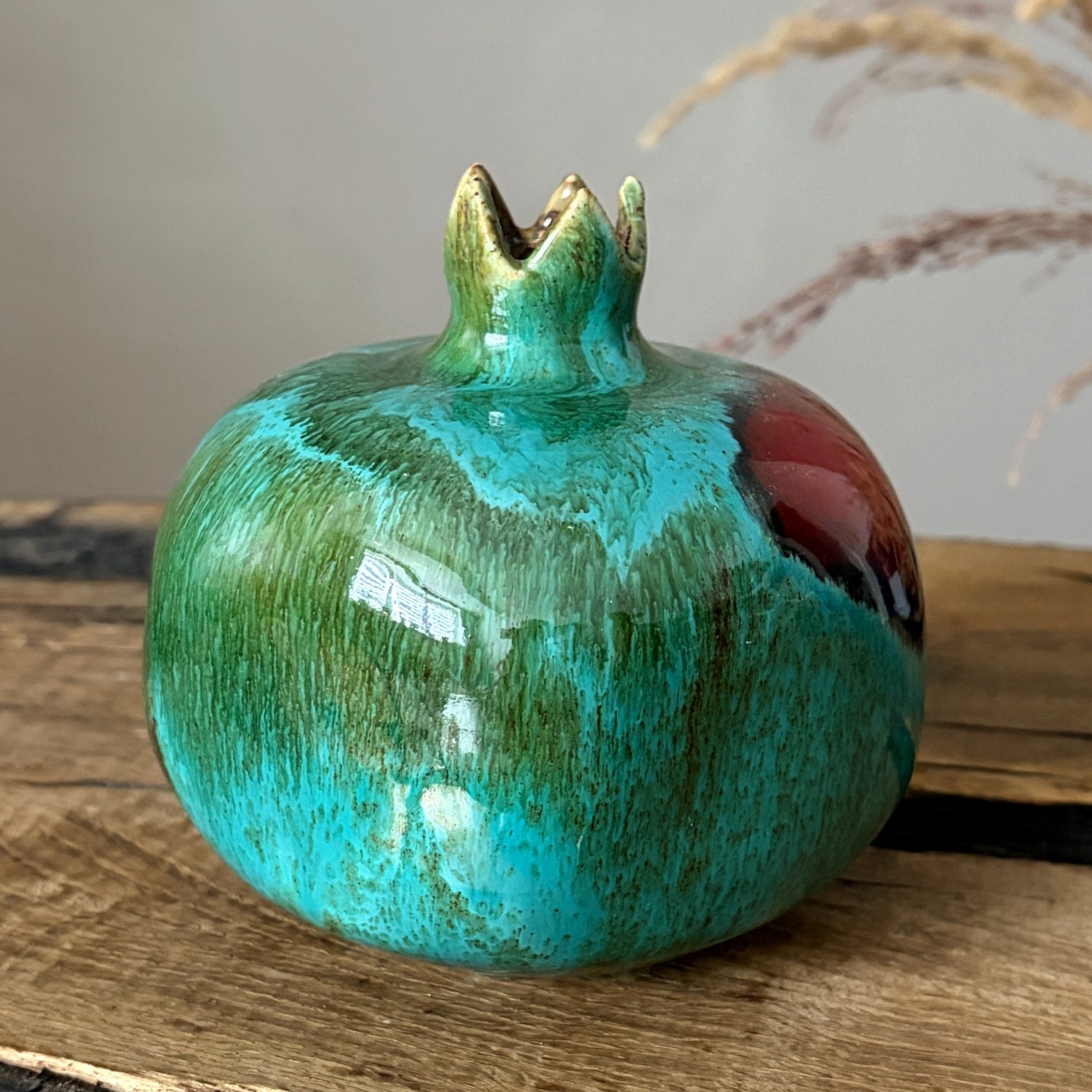 Ceramic pomegranate sculpture with green turquoise glaze and sculpted crown