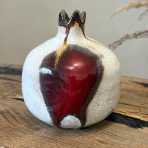 Ceramic fruit ornament featuring ivory crackle surface and deep red glaze