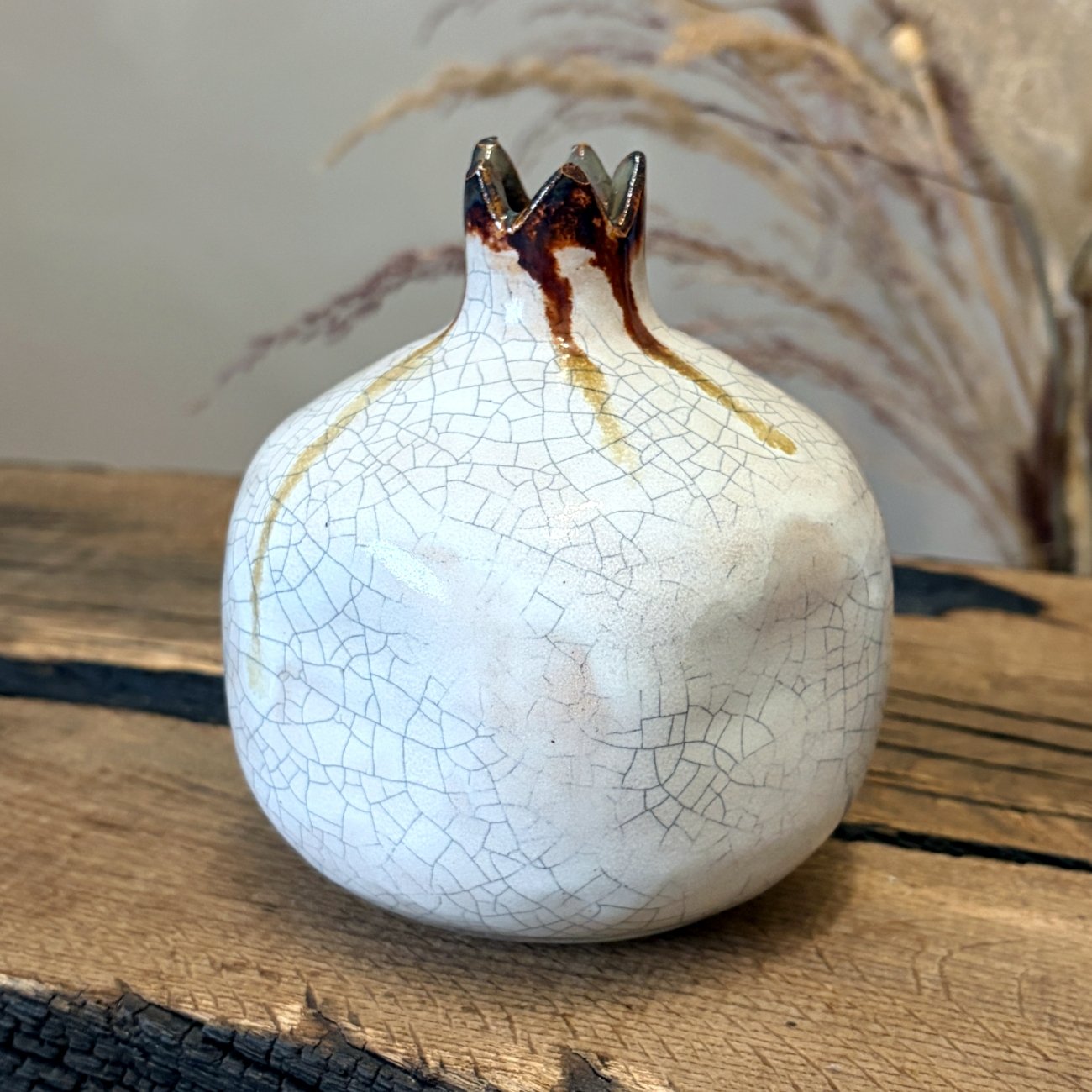 Textured ceramic pomegranate in ivory glaze with subtle brown accents