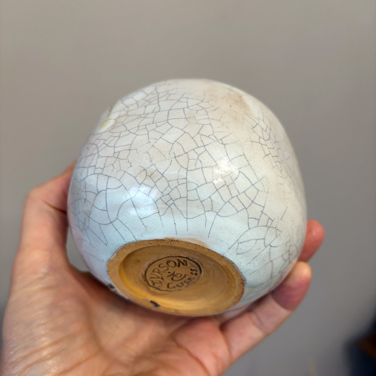 White ceramic pomegranate with red glazed details and crackle texture