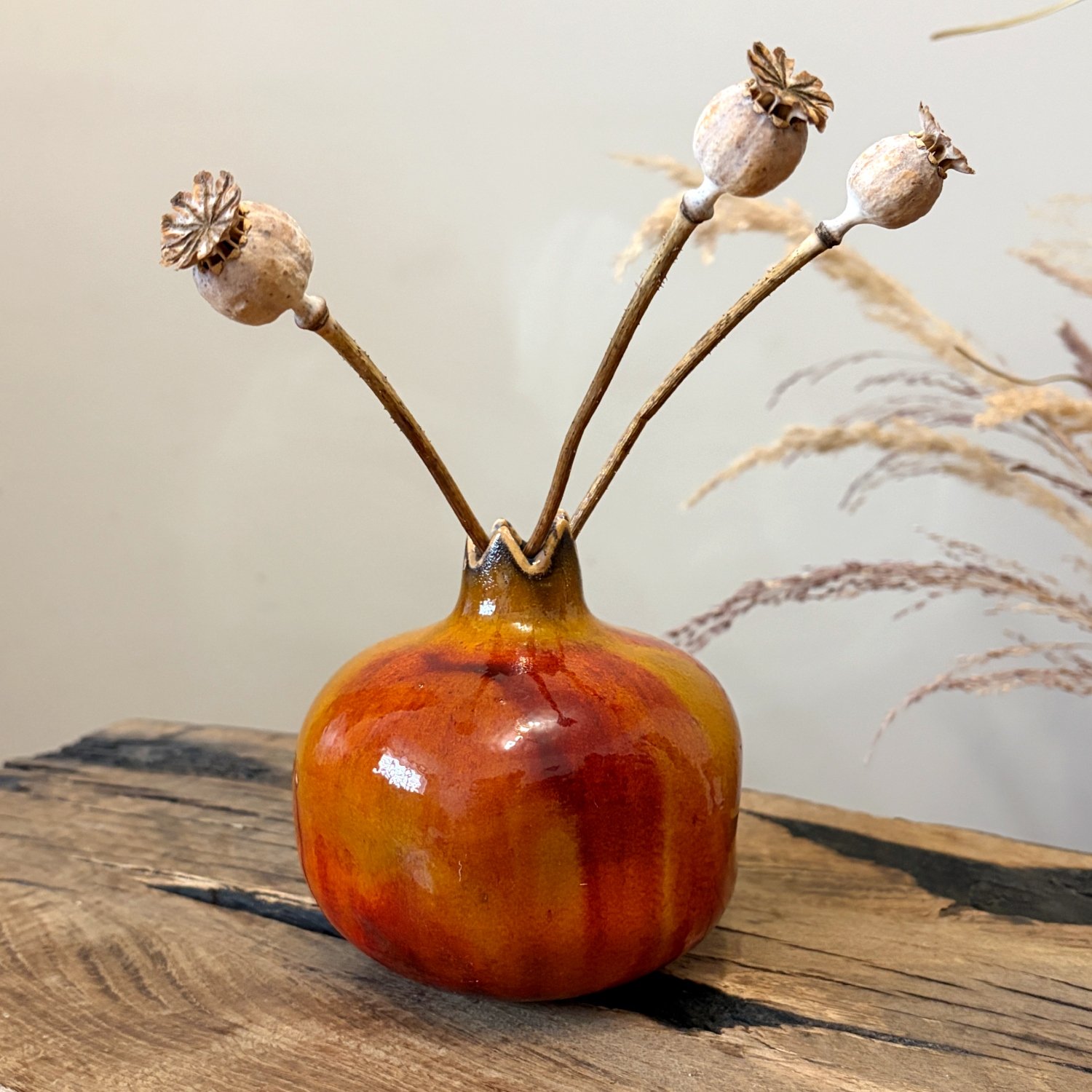 Handmade ceramic pomegranate with warm orange and red glaze