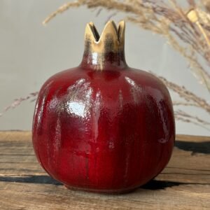 Artisan ceramic pomegranate with crown detail and deep red glaze